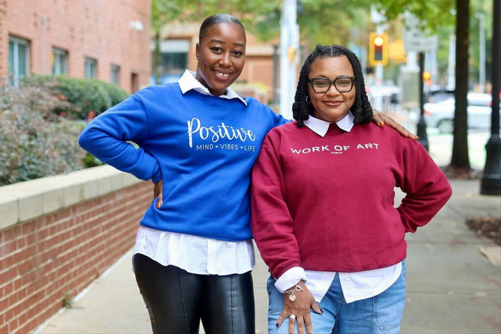Photo by Atlanta Public Schools on October 30, 2025. May be an image of one or more people, people smiling, sweatsuit, sweater, fleece, sweatshirt and text that says 'Dn Postwe MIND-VIBES-LIFE MIND VIBES VIBES-LIFE LIFE WORKOFART OF ART WORK.. Polama'.